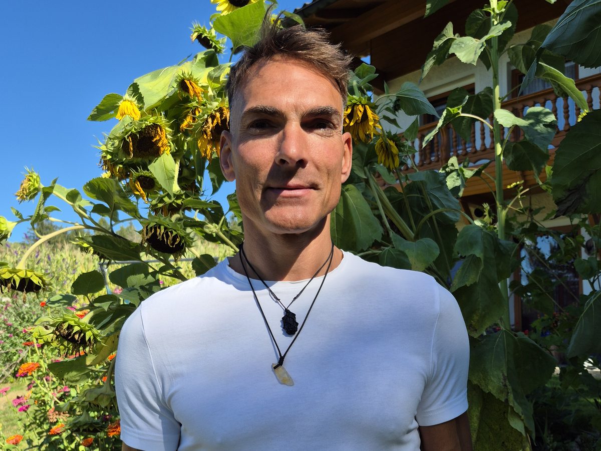 Joachim Kurzner vor Sonnenblumen an seinem Haus im Bayerischen Wald